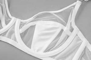 Macro shot of white sheer mesh fabric and smooth silk material on a lace bra detail