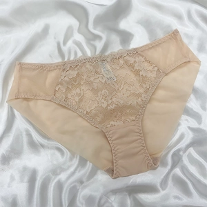 Detailaufnahme von beigen Spitzenunterwäsche mit Blumenstickerei auf glattem Satinstoff