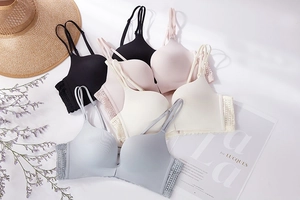 Detailed flat lay of seamless front-buckle bras in multiple pastel colors with lace side wings