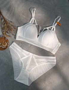 Detailed flat lay of white lace lingerie set with wireless bra and sheer mesh panties