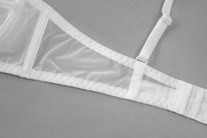Detail of adjustable straps and mesh fabric on a white semi-transparent bra set