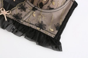 Detailed close-up of floral embroidery, polka dot lace, and a pink satin bow on the bra