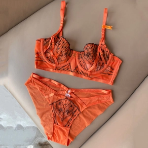 Detail of orange lace bra set with black floral embroidery and unlined underwired cups