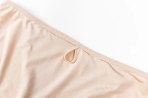 Macro shot of seamless nude silk panties showing smooth texture and elastic edging