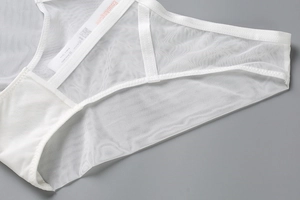 Détail macro du tissu en maille blanche respirante et sangles croisées du slip