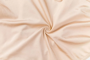 Macro shot of smooth beige seamless fabric texture with soft satin luster and drape