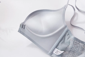Detail view of seamless light blue bra inner cup padding and delicate lace side wing