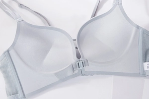 Close-up of front buckle closure on seamless light blue bra with delicate lace side panels