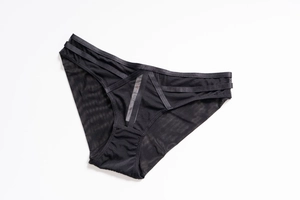 Detail of sheer black mesh panties with criss-cross decorative straps and modern cutout waist