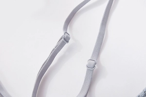 Detail of adjustable elastic shoulder straps with matching plastic buckles in light grey