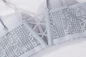 Detail of light blue lace bra featuring criss-cross back straps and breathable side wings