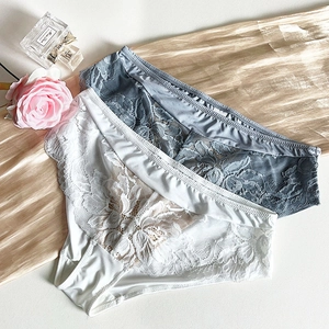 Détail de culottes élégantes en dentelle blanche et bleu-gris avec broderie florale