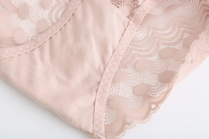 Vue détaillée des coutures en dentelle et du tissu en coton doux sur une culotte rose