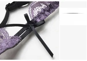 Detail of purple lace bra strap with black satin bow and adjustable metal hardware