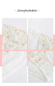 Detail of white mesh lace panties with golden floral embroidery and scalloped edges