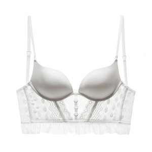 Detail of white lace bustier with heart-shaped buckles and delicate sheer mesh ruffles