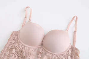 Detail of pink lace bra with heart-shaped buckle and fine floral lace patterns