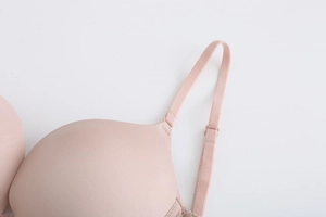 Detail of adjustable strap and seamless pink lace bra cup with smooth fabric texture