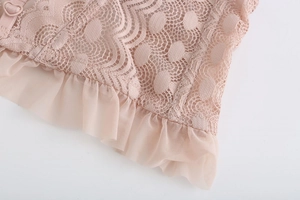 Macro detail of dusty pink lace embroidery and mesh trim on French style bralette