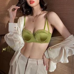 Close-up of sage green satin bra with delicate floral lace and high-quality pearl texture