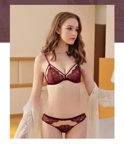 Detailansicht eines weinroten Spitzen-Dessous-Sets mit Blumenstickerei und Netzstruktur