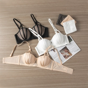 Detailed flat lay of lace bra sets in black, white, and nude on a wooden background