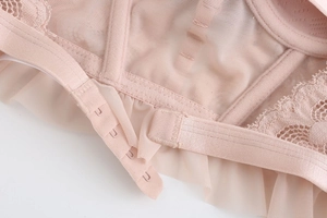 Close-up of pink lace bra featuring multiple back hook-and-eye closures and mesh details