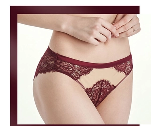 Detalle de bragas de encaje rojo vino con bordados florales y pretina de satén de seda brillante