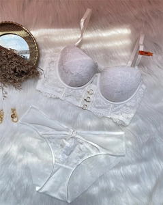 Ensemble soutien-gorge en dentelle blanche avec anneaux dorés sur tapis en fausse fourrure