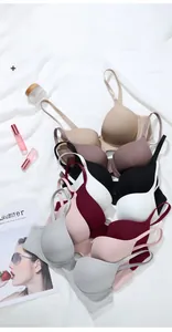 Vue à plat de soutiens-gorge sans couture de diverses couleurs sur tissu blanc épuré