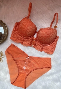 Détail d'un ensemble lingerie en dentelle orange avec anneau doré sur fausse fourrure