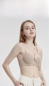 Sleek seamless nude bra with thin straps worn by a professional model on a gray background