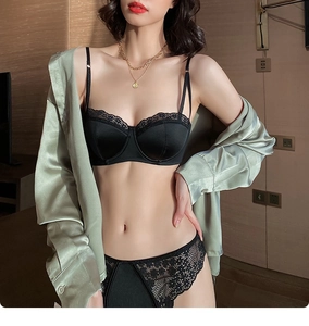 Detail of black satin and lace lingerie set with semi-cup bra on a professional model