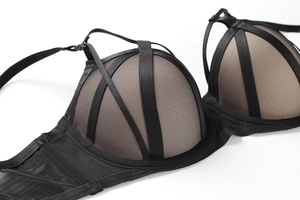 Detail view of black strapless bra with crisscross satin ribbons and sheer mesh fabric