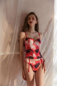 Detail of red and black floral print corset lingerie with garter straps and slim fit