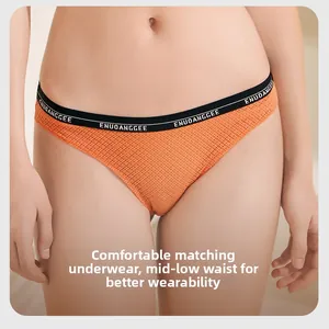 Dettaglio slip in rete arancione con fascia elastica nera decorata con scritte