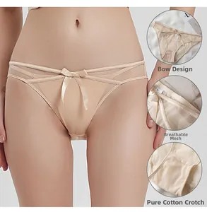 Detail view of skin-colored mesh panties featuring satin bow and cross strap design