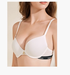 Dettaglio di un reggiseno push-up bianco con trama a nido d'ape ed elastico logato