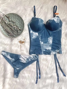 Detailed flat lay of blue tie-dye corset lingerie set with 75B cup size on plush rug
