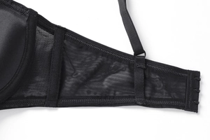 Detail of the black lace bra showing mesh side wings and three-row hook-and-eye closure