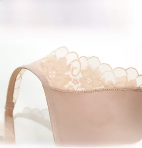 Macro view of French-style lace embroidery and deep V-neckline texture on nude bra