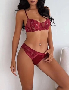 Detailed view of burgundy floral lace bra set with silk texture and sheer side panels