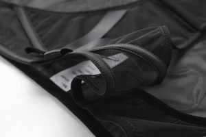 Macro detail of sheer black mesh fabric with diamond pattern and soft lace trim texture
