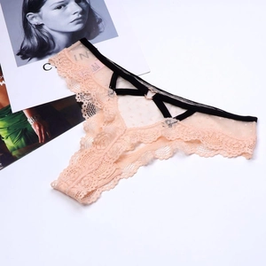 Détails du string en dentelle avec anneau cœur en or rose et lanières croisées