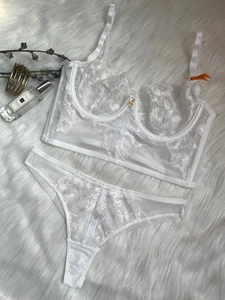 Flat lay of white lace lingerie set featuring delicate embroidery and adjustable straps