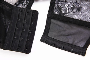 Close-up of black floral lace bra back showing four-row hook and eye closure details