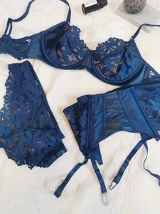Flat lay detail of dark blue lace lingerie set with garter belt and satin trim