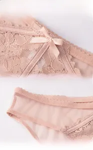 Detail view of pink lace underwear featuring satin bow and elastic wavy waistband