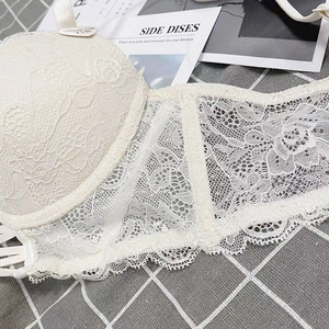 Close-up of white floral lace embroidery and sheer mesh detail on size 75B bra