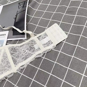 Detail of the white floral lace bra showing four-row hook-and-eye back closure and straps